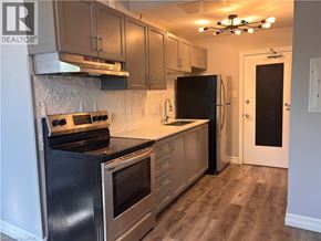 Hamilton apartment for rent - A kitchen with a black stove top oven and a black refrigerator.