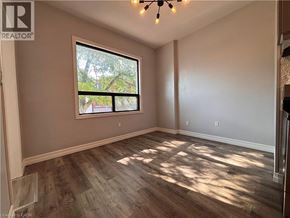 Hamilton apartment for rent - A room with a large window and wooden flooring.