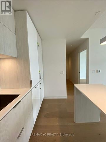 Toronto (Waterfront Communities) condo for rent - A modern kitchen with white cabinets and a countertop.