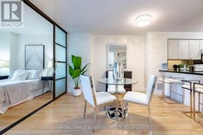 Toronto (Willowdale East) condo for rent - A modern bedroom with a glass wall and a dining area with white chairs.