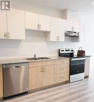Guelph (Willow West/Sugarbush/West Acres) condo for rent - A modern kitchen with wooden cabinets and stainless steel appliances.