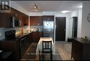 Richmond Hill (Doncrest) condo for rent - A kitchen with dark wood cabinets and a black refrigerator.
