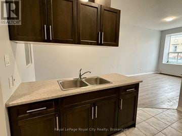 Guelph (Downtown) multi-family for rent - A kitchen with brown cabinets and a granite countertop.