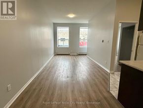 Guelph (Downtown) multi-family for rent - A room with wooden flooring and a window showing a street view.