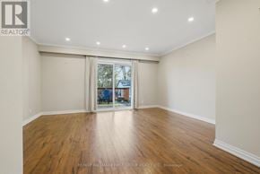 Whitby (Williamsburg) apartment for rent - A spacious room with wooden flooring and a sliding glass door leading to a balcony.