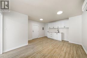Toronto (Kensington-Chinatown) condo for rent - A white room with wooden flooring and a large white cabinet.
