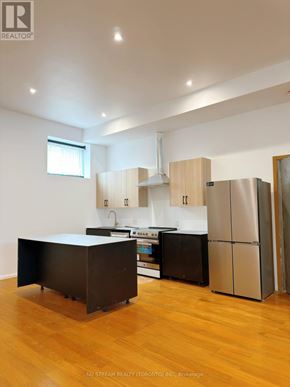 Toronto (Bathurst Manor) apartment for rent - A kitchen with wooden cabinets and a black island.