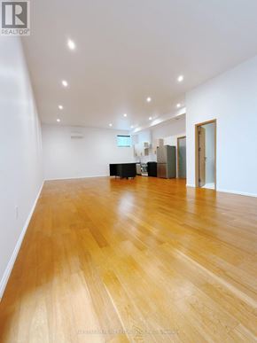 Toronto (Bathurst Manor) apartment for rent - A room with wooden floors and white walls.