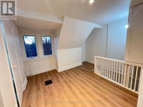 Toronto (South Riverdale) apartment for rent - A room with wooden floors and white walls, with a window and a door visible.
