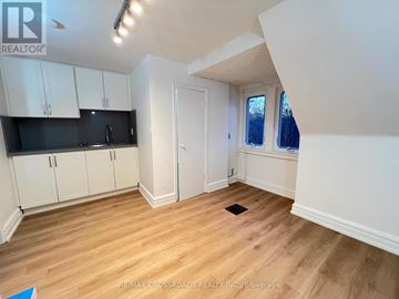 Toronto (South Riverdale) apartment for rent - A kitchen with white cabinets and a black countertop.