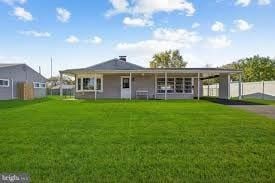 Levittown apartment for rent - A house with a grey roof and a green lawn in front.