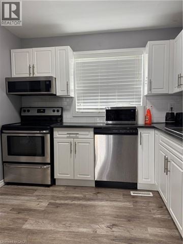 Waterloo townhouse for rent - A kitchen with white cabinets and stainless steel appliances.