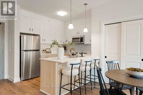 London North (North B) multi-family for rent - A modern kitchen with a stainless steel refrigerator and white cabinets.