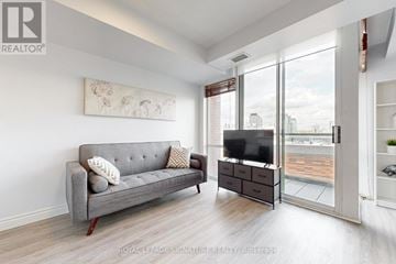 Toronto (Waterfront Communities) condo for rent - A living room with a grey couch and a television.