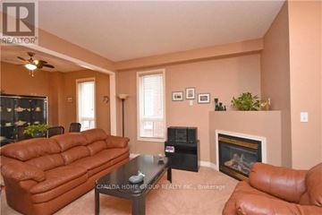 Mississauga (Churchill Meadows) apartment for rent - A living room with a brown leather couch and a black coffee table.