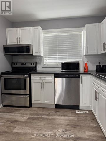 Waterloo townhouse for rent - A kitchen with white cabinets and stainless steel appliances.