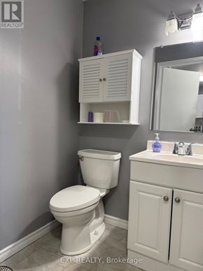 Waterloo townhouse for rent - A white toilet sits next to a white sink in a bathroom.