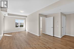Woodstock (Woodstock - South) apartment for rent - A spacious room with wooden flooring and white walls, with a window showing a view of trees and houses.