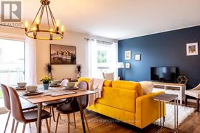 Kitchener apartment for rent - A living room with a yellow couch and a dining table with chairs.