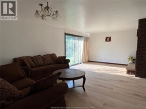 Windsor apartment for rent - A living room with a brown couch and a chandelier.