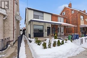 Toronto (Palmerston-Little Italy) apartment for rent - A snow-covered sidewalk leads to a modern building with a glass entrance.