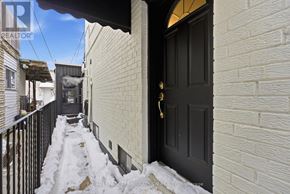 Toronto (Palmerston-Little Italy) apartment for rent - A snowy alley with a black door and a sign that says REALTOR.