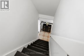 Toronto (Palmerston-Little Italy) apartment for rent - A staircase with a carpeted runner and a black handrail.