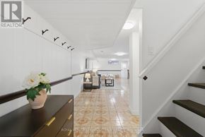 Toronto (Palmerston-Little Italy) apartment for rent - A hallway with a flower vase on a table and a staircase on the right.