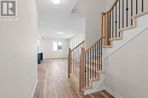 Ottawa townhouse for rent - A staircase with a wooden handrail and a beige carpeted runner.