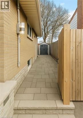 Hamilton apartment for rent - A wooden fence leads to a garage.
