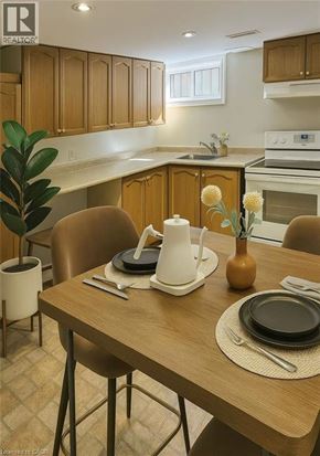 Hamilton apartment for rent - A kitchen with a table set for two with a vase of flowers on it.