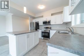 Thorold (Hurricane/Merrittville) apartment for rent - A kitchen with white cabinets and a grey countertop.