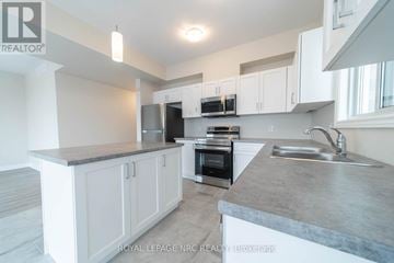 Thorold (Hurricane/Merrittville) apartment for rent - A kitchen with white cabinets and a grey countertop.