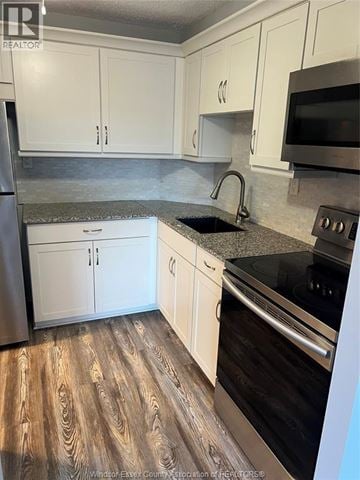 Windsor condo for rent - A kitchen with white cabinets and a black stove top oven.