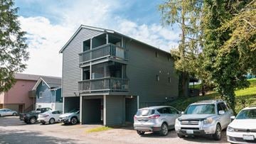 Bellingham apartment for rent - A grey two-story apartment building with a balcony and a garage door.