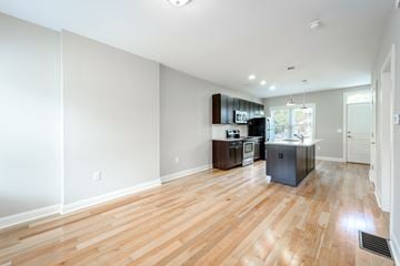 Columbus apartment for rent - A kitchen with a sink, stove, and refrigerator in a room with wooden floors.