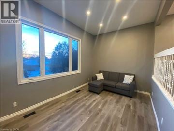 Kitchener townhouse for rent - A living room with a grey couch and a large window.