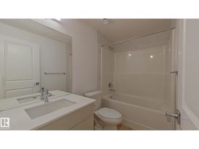 Edmonton apartment for rent - A white bathroom with a toilet, sink, and bathtub.