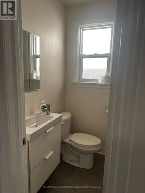 Toronto (Woodbine-Lumsden) apartment for rent - A white bathroom with a toilet, sink, and mirror.