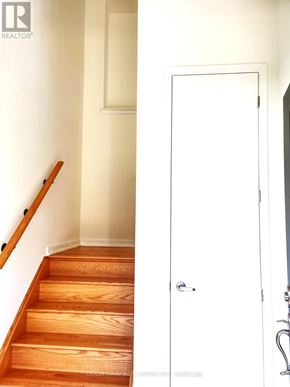 Markham (Wismer) townhouse for rent - A white door is in a hallway with wood floors and a white wall.
