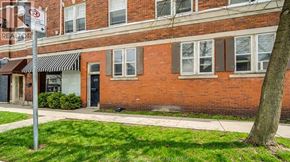 Windsor apartment for rent - A red brick building with a black awning and a sign that says "REALTOR".