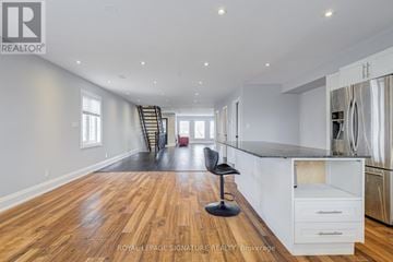 Toronto (Keelesdale-Eglinton West) multi-family for rent - A spacious kitchen with white cabinets and a black countertop.