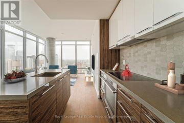 Toronto (University) condo for rent - A modern kitchen with wooden cabinets and stainless steel appliances.