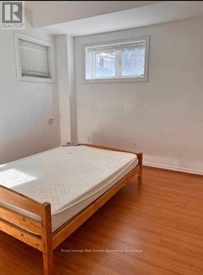 Markham (Victoria Square) apartment for rent - A bedroom with a bed, wooden floors, and two windows.