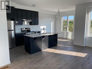 Kitchener townhouse for rent - A kitchen with black cabinets and a black island.