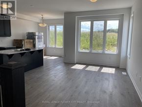 Kitchener townhouse for rent - A room with a large window and a kitchen area.