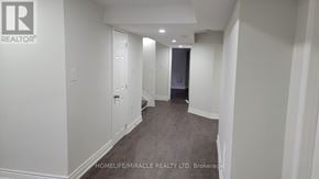 Clarington (Bowmanville) apartment for rent - A hallway with a brokerage sign on the wall.