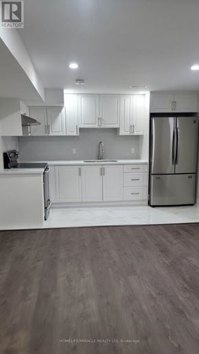 Clarington (Bowmanville) apartment for rent - A kitchen with white cabinets and a stainless steel refrigerator.