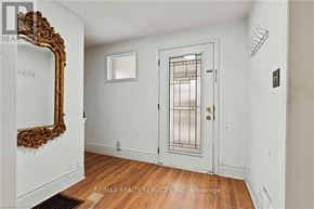 Niagara Falls (Cherrywood) apartment for rent - A room with a white door, a mirror, and a wooden floor.