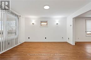 Niagara Falls (Cherrywood) apartment for rent - A room with wooden floors and white walls, with a window and a door visible.